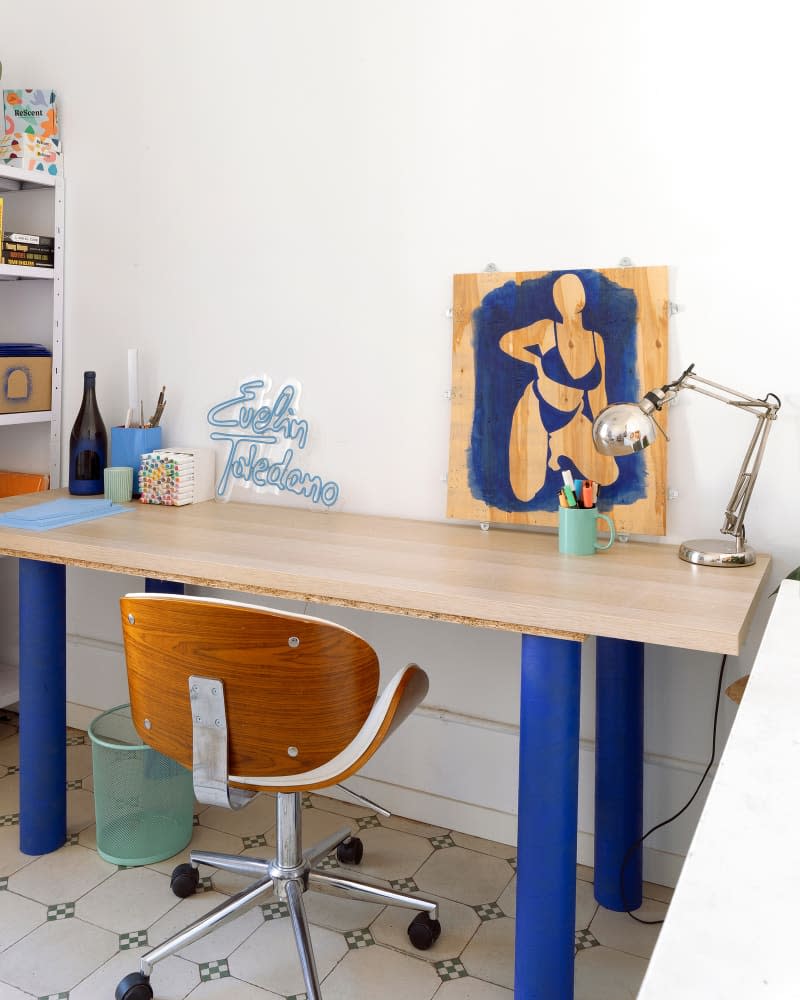 Art space with metal lamp and blow desk legs.