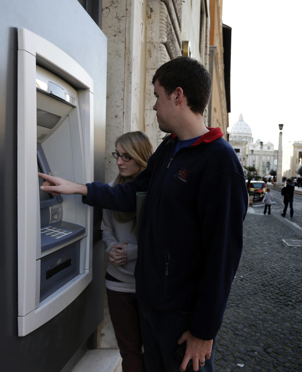 Ben Kiniry, of Texas, gets cash from an ATM machine along Via della Conciliazione, the main road leading to St. Peter's Basilica at the Vatican, Thursday, Jan. 3, 2013. It's "cash only" now for tourists at the Vatican wanting to pay for museum tickets, souvenirs and other services after Italy's central bank decided to block electronic payments, including credit cards, at the tiny city state. The Italian daily Corriere della Sera reported Thursday that Bank of Italy took the action because the Holy See has not yet fully complied with European Union safeguards against money laundering. That means Italian banks are not authorized to operate within the Vatican, which is in the process of improving its mechanisms to combat laundering. The Vatican says it's scrambling to find a non-Italian bank to provide the electronic payment services "quite soon" but declined to discuss Bank of Italy's concerns. The central bank had no immediate comment on the situation. (AP Photo/Alessandra Tarantino)