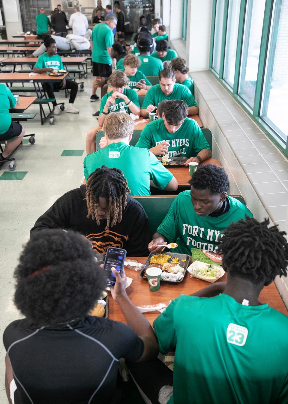 Fort Myers High School football players eat their pre-game meal on Thursday, Oct. 19, 2023, at Fort Myers High School. Volunteers make a meal for the students to eat before each game.