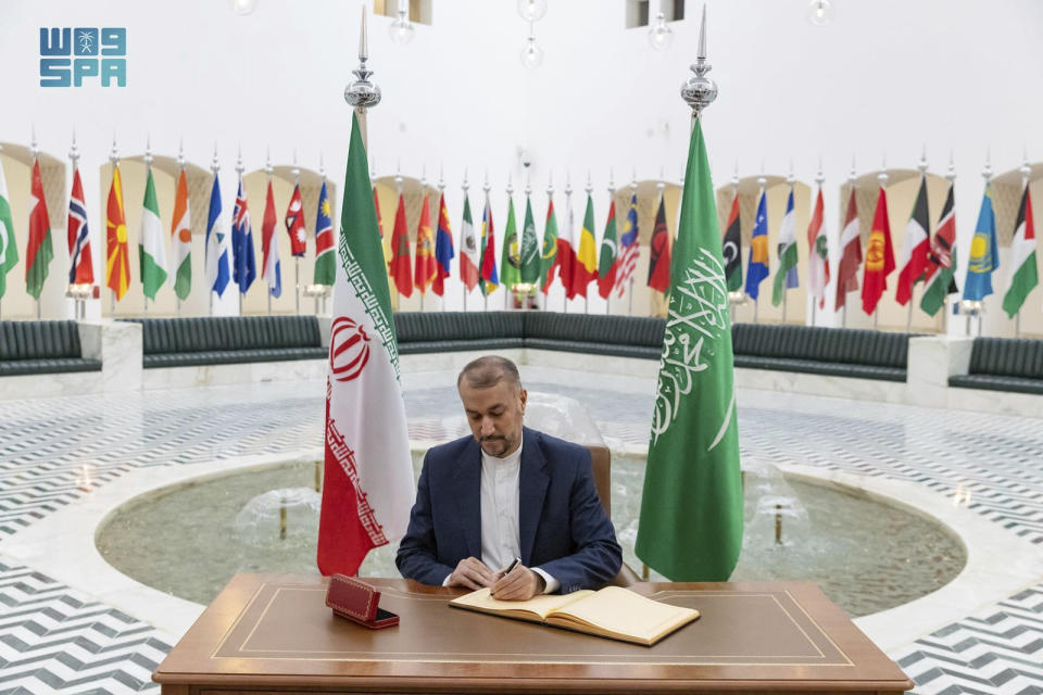 In this handout image released by the state-run Saudi Press Agency, Iranian Foreign Minister Hossein Amirabdollahian signs a register at the Saudi Foreign Ministry in Riyadh, Saudi Arabia, Thursday, Aug. 17, 2023. Iran's foreign minister traveled to Saudi Arabia on Thursday, marking the first trip to the kingdom by Tehran's top diplomat in years after the two nations reached a détente with Chinese mediation. (Abdulrahman al-Abdulsalam/Saudi Press Agency, via AP)