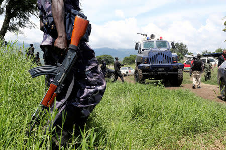 A Uganda policeman holds his weapon during a search at one of the Rwenzururu kingdom royal guard huts at one of the kingdom’s shrines near Kasese town, in western Uganda bordering bordering with Democratic Republic of Congo November 29, 2016. REUTERS/James Akena