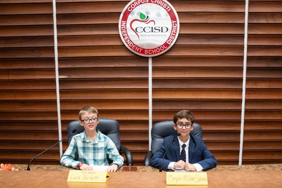Windsor Park third grade students Luca Burke, left, and Milan Sahadi, pre-elected to a mock city council, are seated at the head of the CCISD school board room before a debate on community gardens on Tuesday, Oct. 24, 2023, in Corpus Christi, Texas.