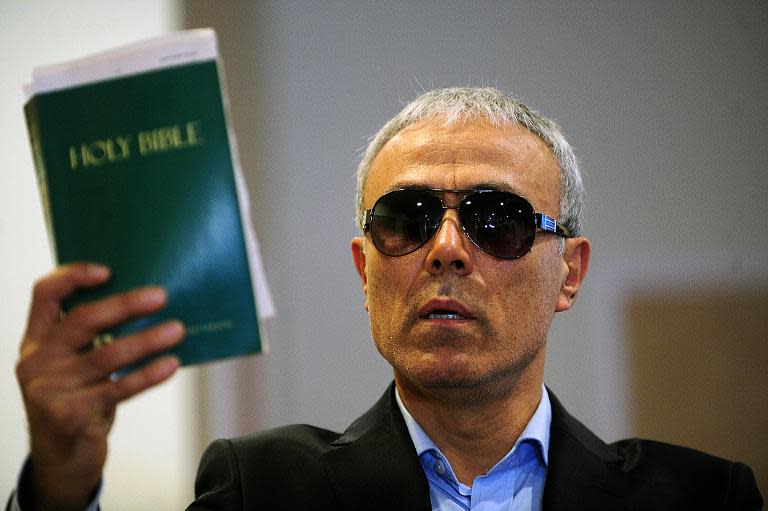 Mehmet Ali Agca, the Turkish man who attempted to assassinate Pope John Paul II in 1981, holds a copy of the Bible during a press conference in Istanbul on November 27, 2014