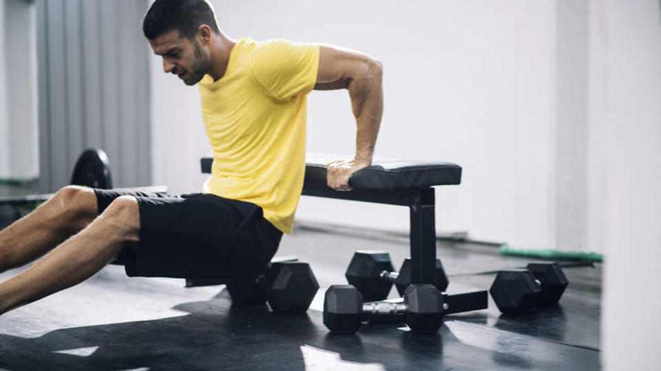 Man performs a triceps dip on a bench