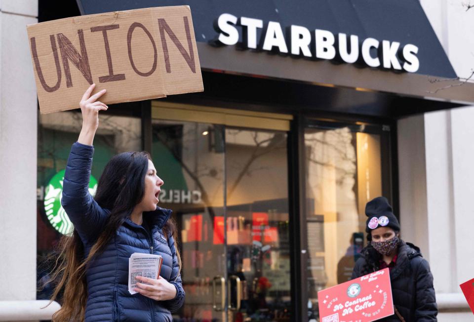 Steph Kronos (L), a pro-Union activist, joins Starbucks workers, former employees, and supporters in holding signs in support of a strike, outside of a Starbucks store in Arlington, Virginia, on November 16, 2023. The workers are striking on Red Cup Day, where Starbucks gives out collectible, reusable red cups with every drink purchase to celebrate the holidays, making it one of the busiest days of the year for the company.