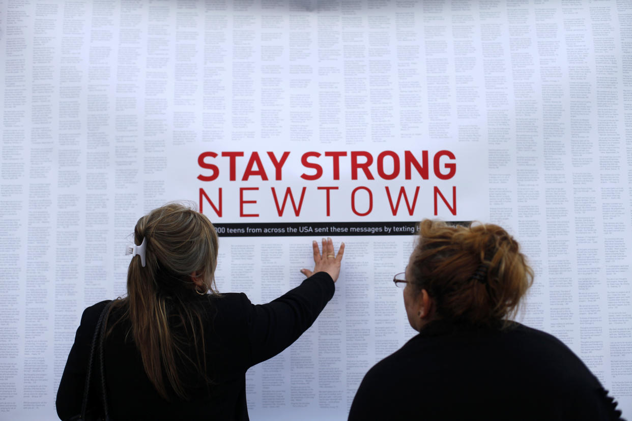 A woman touches a printout of messages of support and shared grief from teenagers around the United States at a memorial for the victims of the Sandy Hook Elementary School shooting in Newtown, Conn., Dec. 18, 2012. (Photo: Joshua Lott/Reuters)