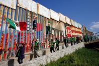 FILE PHOTO: Migrants and members of civil society hold pinatas during a protest in Tijuana