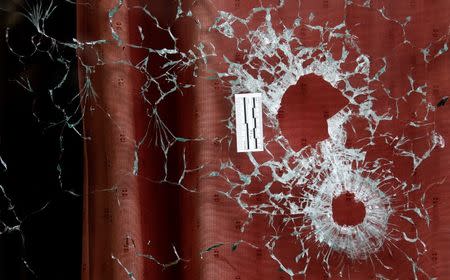 Bullet impacts are seen in the window of the Le Carillon restaurant the morning after a series of deadly attacks in Paris , November 14, 2015. REUTERS/Christian Hartman