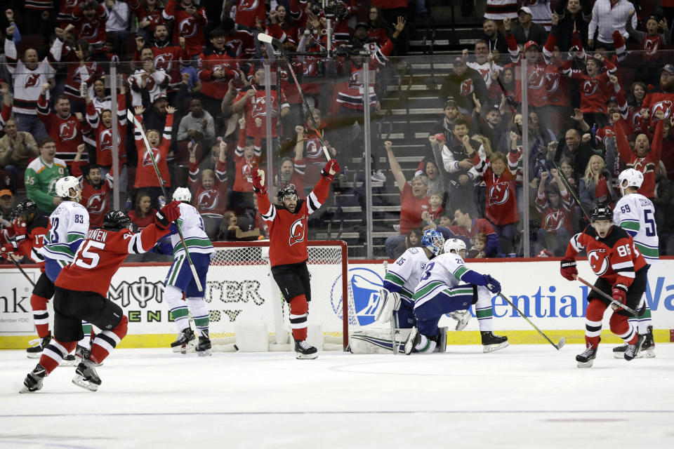 New Jersey Devils' Jack Hughes, right, celebrates with teammates after scoring a goal during the first period of an NHL hockey game against the Vancouver Canucks, Saturday, Oct. 19, 2019, in Newark, N.J. (AP Photo/Frank Franklin II)