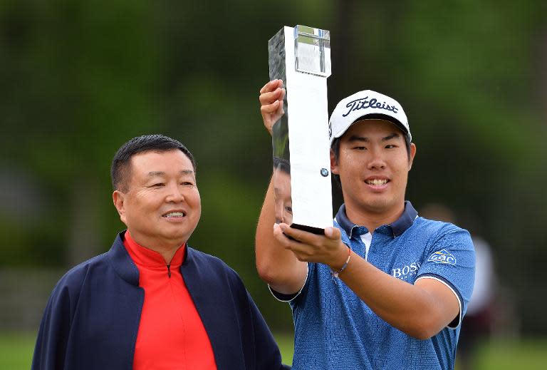 Dr. Chanchai Ruayrungruang (L) chairman of Wentworth stands beside Korean golfer Byeong-hun An, as he celebrates with the trophy after winning the PGA Championship at Wentworth Golf Club in Surrey, south west of London on May 24, 2015