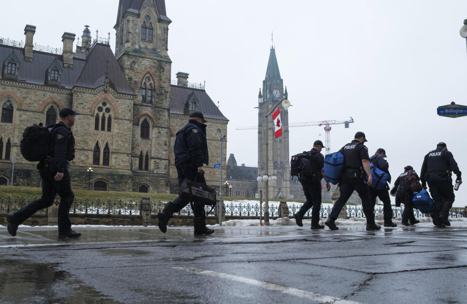 RCMP officers make their way to a bus as they head off Parliament Hill, in Ottawa, before the visit by U.S. President Joe Biden to Canada, on Thursday, March 23, 2023. (Justin Tang /The Canadian Press via AP)