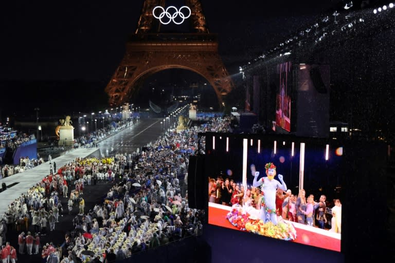 Delegaciones olímpicas llegando a Trocadero mientras el público sigue por pantalla al cantante francés Philippe Katerine, el 26 de julio de 2024 durante la inauguración de París-2024 (Ludovic MARIN)