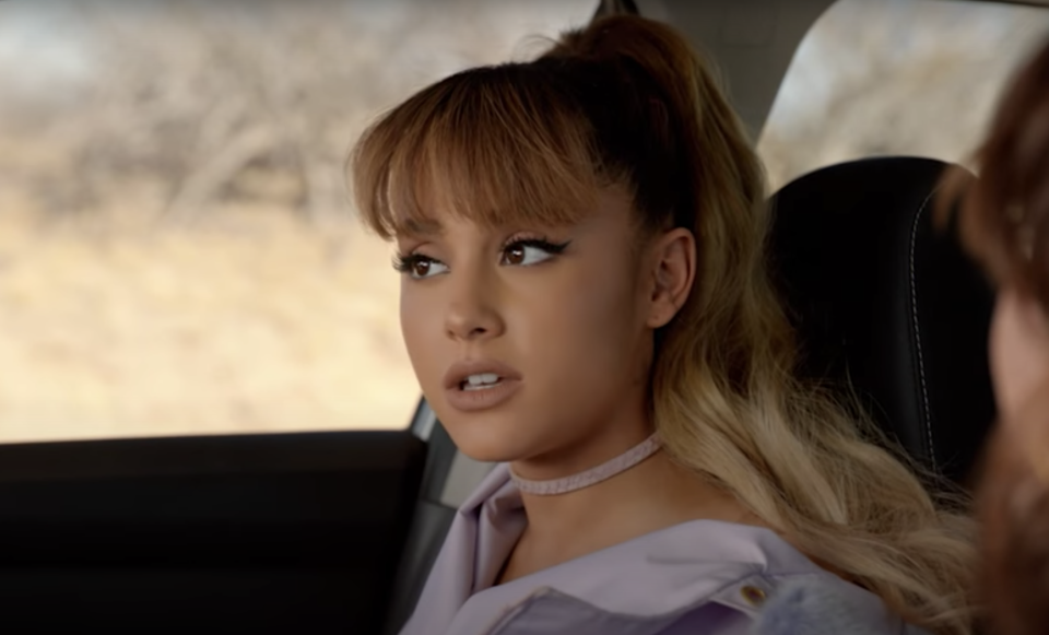 Ariana Grande regarde par la fenêtre d'une voiture