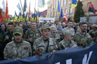Ukrainian army veterans attend a rally marking Defense of the Homeland Day in center Kyiv, Ukraine, Monday, Oct. 14, 2019. Some 15,000 far-right and nationalist activists protested in the Ukrainian capital, chanting "Glory to Ukraine" and waving yellow and blue flags. President Volodymyr Zelenskiy urged participants to avoid violence and warned of potential “provocations” from those who want to stoke chaos. (AP Photo/Efrem Lukatsky)
