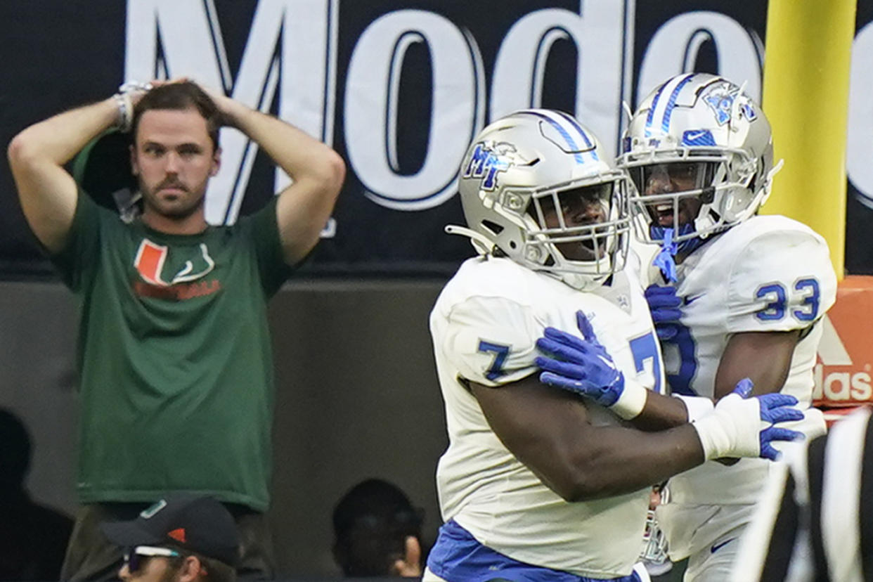 Middle Tennessee defensive tackle Zaylin Wood (7) celebrates with cornerback Decorian Patterson (33) after Wood intercepted the ball and scored against Miami, Saturday, Sept. 24, 2022, in Miami Gardens, Fla. (AP Photo/Wilfredo Lee)