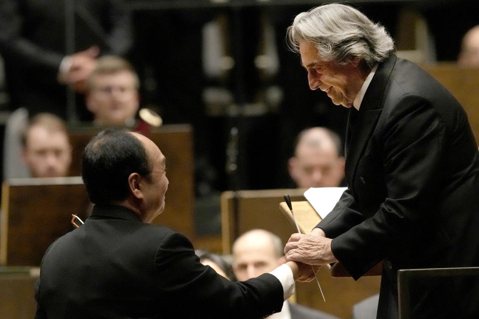 Riccardo Muti, musical director of the Chicago Symphony Orchestra, right, shakes hands with Concertmaster Robert Chen, after conducting the orchestra and chorus in Beethoven's "Missa Solemnis" in D Major, Op. 123, Sunday, June 25, 2023, in Chicago. Sunday marked the last performance by Muti, 81, in Orchestra Hall during his 13 year tenure. (AP Photo/Charles Rex Arbogast)