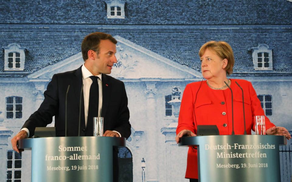 French President Emmanuel Macron and German Chancellor Angela Merkel share a press conference after bilateral talks  - AFP