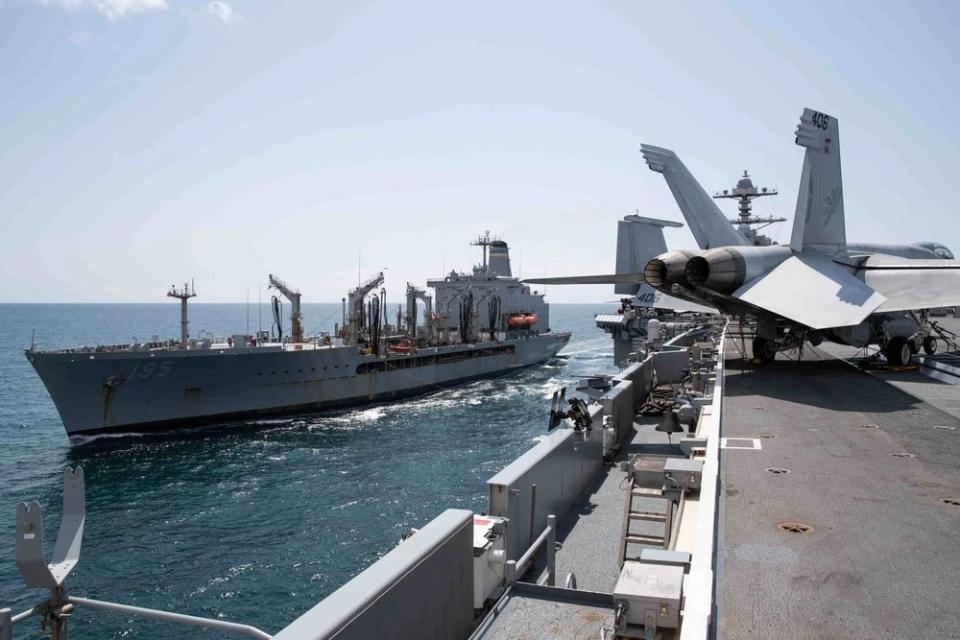 Two military ships, one with an aircraft on board, are shown at sea