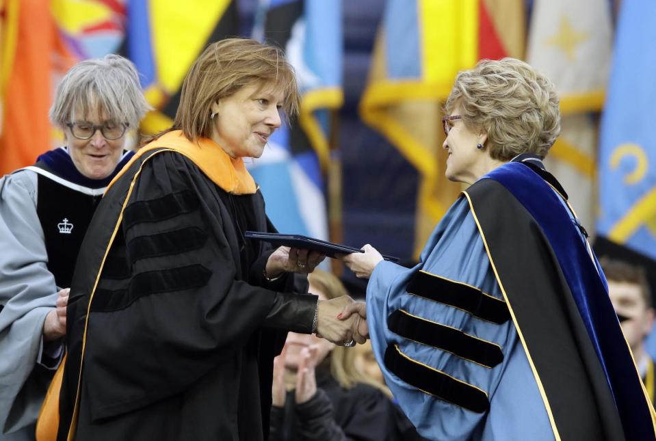 General Motors CEO Mary Barra, left, is conferred an honorary Doctor of Engineering degree by Michigan President Mary Sue Coleman, before addressing the University of Michigan graduates at a commencement ceremony Saturday, May 3, 2014 in Ann Arbor, Mich. Barra, the first woman to lead a major automaker, took the top spot at GM in January, just as a deadly ignition switch problem was starting to surface. Barra urged the students to be honest in every aspect of their lives, and to use their optimism and propensity for inclusion to rethink outdated assumptions and expose and correct injustice. (AP Photo/Carlos Osorio)