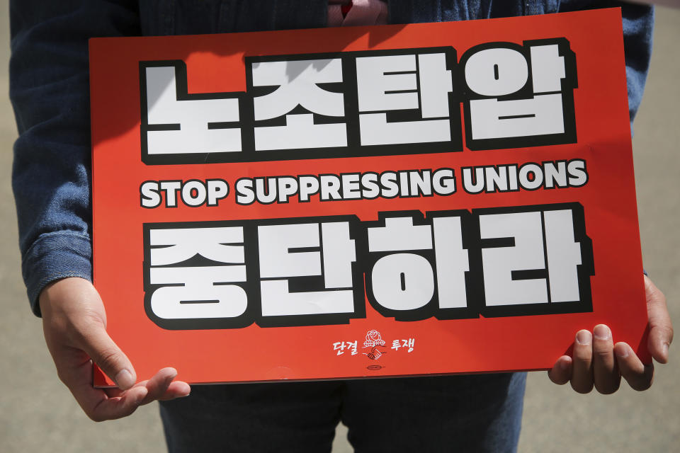 Public sector worker Hong Doo-jung, 25 years old of Worcester, holds a sign during the arrival of South Korea's President Yoon Suk Yeol at the Massachusetts State House, Friday, April 28, 2023, in Boston, Mass. Yoon stopped at the State House ahead of a talk at Harvard University as he wrapped up a state visit to the United States. (AP Photo/Reba Saldanha)