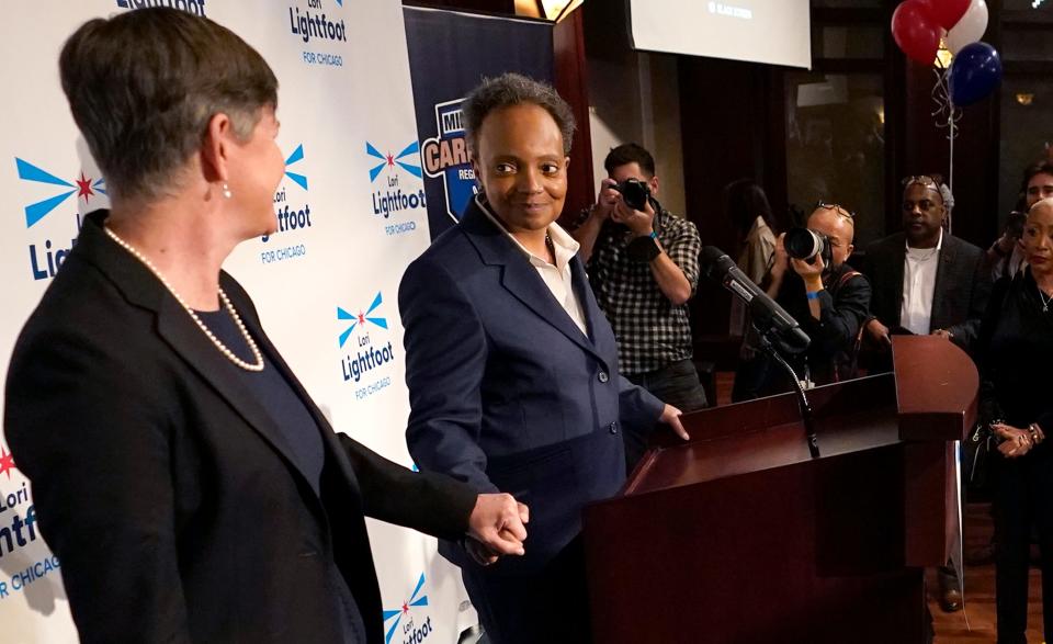 Chicago Mayor Lori Lightfoot, at podium, holds hands with her spouse, Amy Eshleman, as she concedes the election in the mayoral race, Tuesday, Feb. 28, 2023, in Chicago.