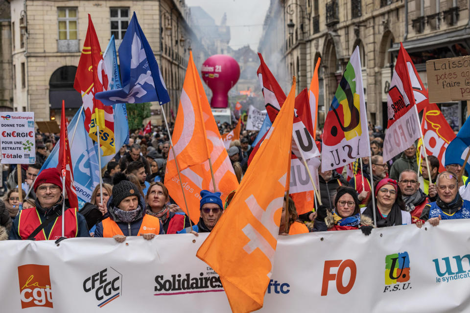 Protesters hold flags and a banner with the logos of French trade unions such as (L/R) CGT, CFE-CGE, Solidaires, CFTC, FO and FSU, as they participate in a demonstration in Dijon, central-eastern France on March 7, 2023, on the sixth day of nationwide rallies organized since the start of the year against French President's pension reform and its postponement of the legal retirement age from 62 to 64. - Massive strikes are expected from March 7, 2023, with unions promising to bring the country 