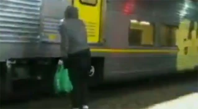 One of the vandals lifts his head to see a train rapidly approaching. Photo: 7 News