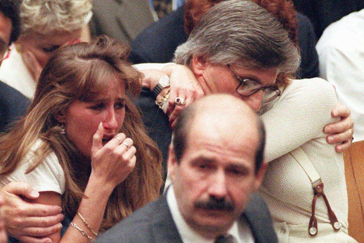 <span>Fred Goldman hugs his wife, Patti, as his daughter, Kim, reacts to the not-guilty verdicts in OJ Simpson’s double-murder trial on 3 October 1995.</span><span>Photograph: Myung J Chun/AP</span>