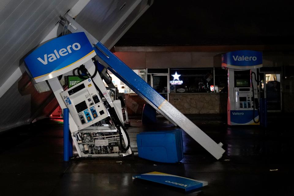 a gas station canopy toppled over gas pumps