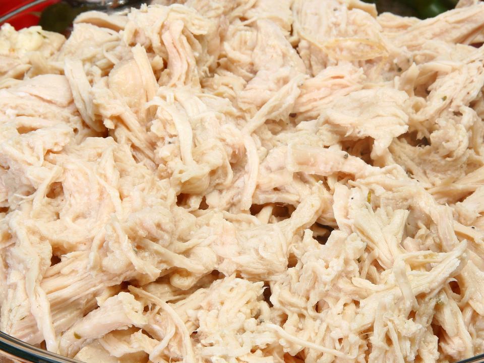 shredded white chicken meat in a glass bowl