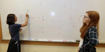 Kaila Morris, left, and Claire Hofstra plan out a strategy on the computer game "Heroes of the Storm," at Hathaway Brown School, Wednesday, July 10, 2019, in Shaker Heights, Ohio. Hathaway Brown launched the country's first varsity esports program at an all-girls school. (AP Photo/Tony Dejak)