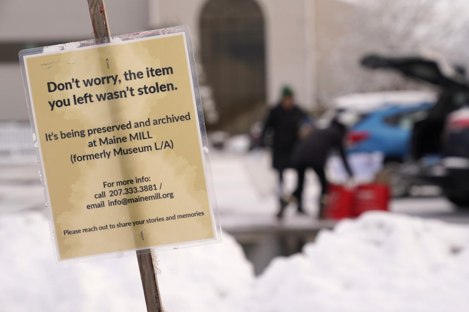 A sign announces the beginning of a project to preserve items left at makeshift memorials for the victims of last month's mass shooting in Lewiston, Maine, Tuesday, Dec. 5, 2023. With winter approaching, officials began removing memorials to the 18 people killed. The items will be cataloged, archived and displayed in a museum. (AP Photo/Robert F. Bukaty)
