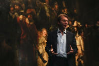 Museum director Taco Dibbits explains how Rembrandt's biggest painting the Night Watch just got bigger with the help of artificial intelligence in Amsterdam, Netherlands, Wednesday, June 23, 2021. Right above Dibbits, left, one of the added parts is seen, the Dutch national museum and art gallery reveals findings from a long-term project to examine in minute detail Rembrandt van Rijn's masterpiece the Night Watch. (AP Photo/Peter Dejong)