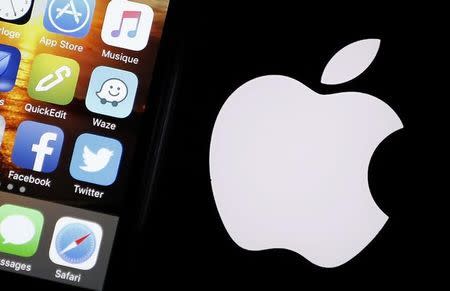 An Apple iPhone is pictured next to the logo of Apple in Bordeaux, southwestern France, February 26, 2016. REUTERS/Regis Duvignau