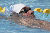 Michael Phelps warms up prior to competing in the 100-meter butterfly during the Arena Grand Prix swim meet, Thursday, April 24, 2014, in Mesa, Ariz. It is Phelps' first competitive event after a nearly two-year retirement. (AP Photo/Matt York)