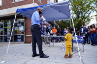 Former President Barack Obama speaks speaks to volunteers outside of a Democratic Voter Activation Center as he campaigns for Democratic presidential candidate former Vice President Joe Biden, Wednesday, Oct. 21, 2020, in Philadelphia, as a child watches. (AP Photo/ Matt Slocum)