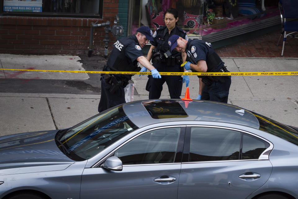 <p>Police investigate a car with a bullet hole within the scene of a shooting in east Toronto, on July 23, 2018. Police were trying Monday to determine what prompted a 29-year-old man to go on a shooting rampage in a popular Toronto neighborhood. (Photo: Christopher Katsarov/The Canadian Press via AP) </p>