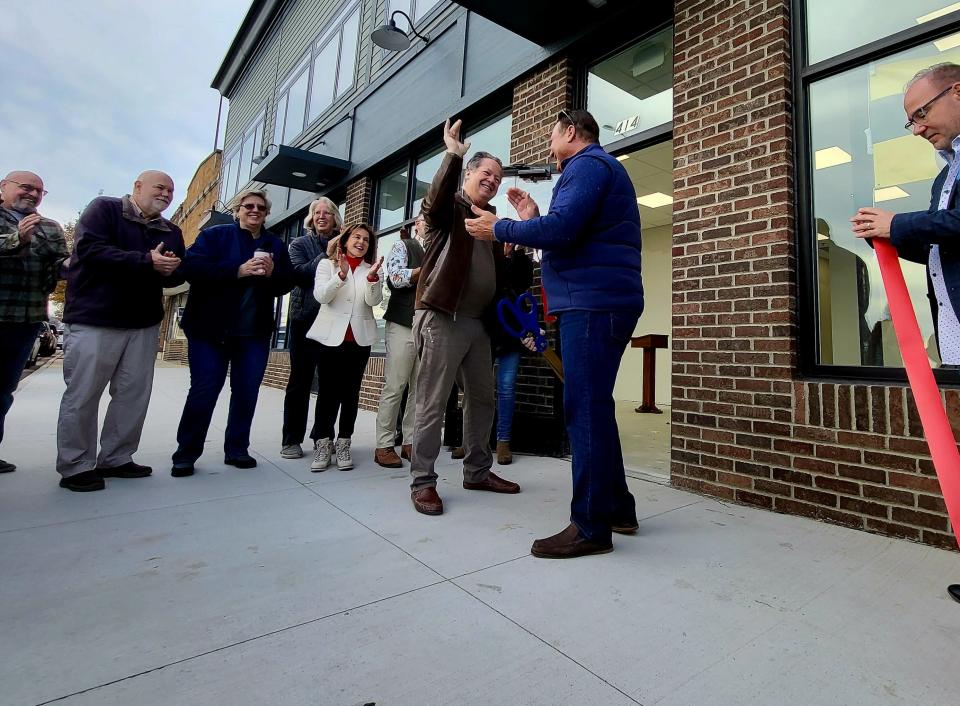 Developers Tom Vertin, left, and Chris LaBelle go in for a hug on Monday, Nov. 20, 2023, following a formal ribbon cutting of their Marine City Manor development.