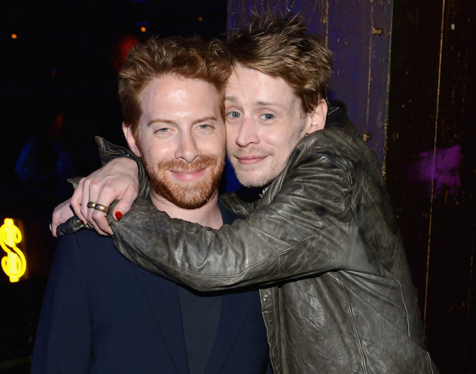 Macaulay Culkin with his arms around Seth Green posing for a photo in 2012