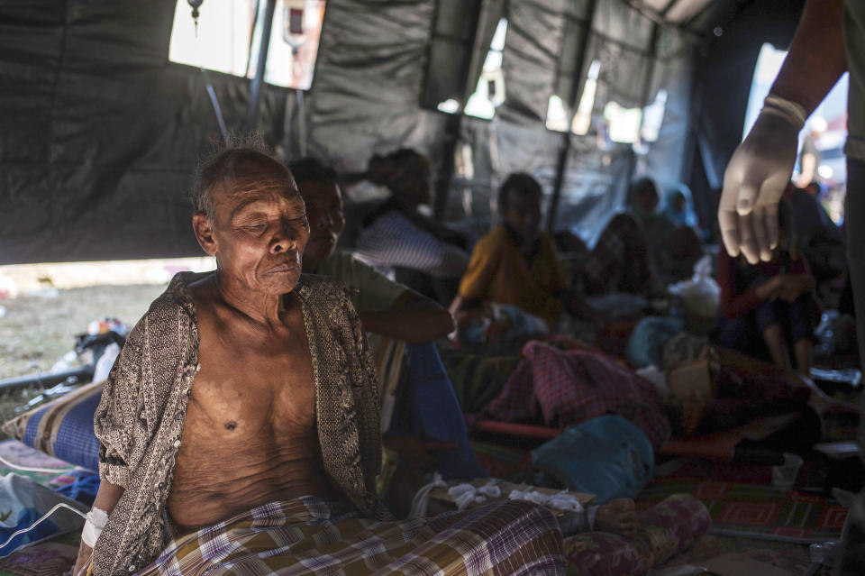 In this Monday, Aug. 6, 2018, photo, an elderly man rests in a makeshift hospital after surviving a major earthquake in Kayangan on Lombok Island, Indonesia. (AP Photo/Fauzy Chaniago)