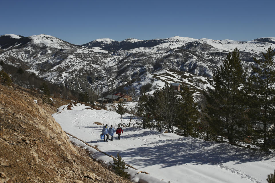 Doctors and health workers of a COVID-19 vaccination team walk in the isolated village of Gumuslu in the district of Sivas, central Turkey, Friday, Feb. 26, 2021. After traveling snow and ice covered roads, medical workers arrived in the small settlement of 350 people some 140 miles (230 kilometers) from the provincial capital, to vaccinate older villagers. (AP Photo/Emrah Gurel)