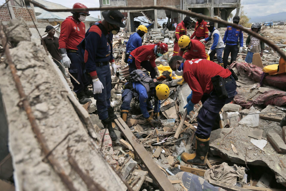 Firemen dig through the rubble in search for tsunami victims in Palu, Central Sulawesi, Indonesia, Thursday, Oct. 11, 2018. A 7.5 magnitude earthquake rocked Central Sulawesi province on Sept. 28, triggering a tsunami and mudslides that killed a large number of people and displaced tens of thousands of others. (AP Photo/Dita Alangkara)