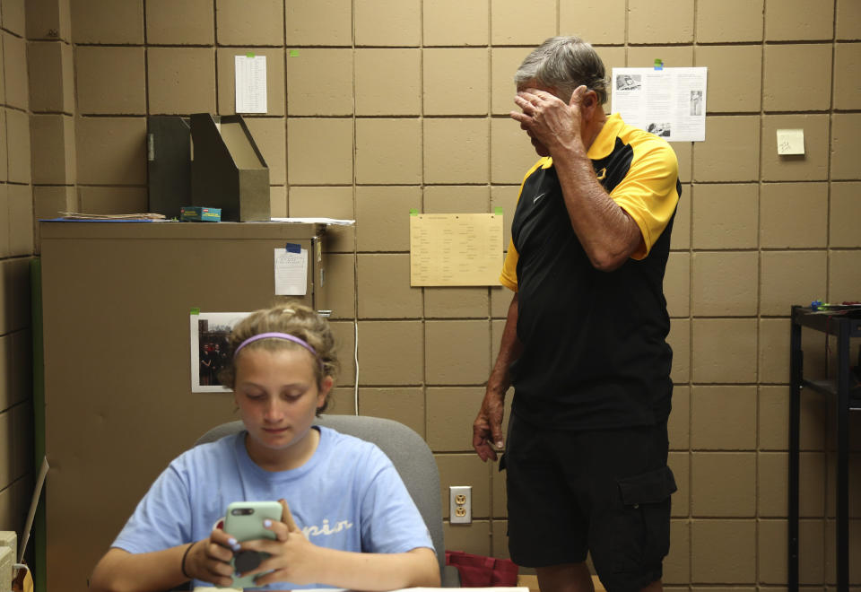 Cesa Pusateri, 12, accompanies her grandfather Timothy Waxenfelter, principal of Quigley Catholic High School, as he cleans out his office in Baden, Pa., Monday, June 8, 2020. The staff was informed of the school's closure May 29 via videoconference. (AP Photo/Jessie Wardarski)