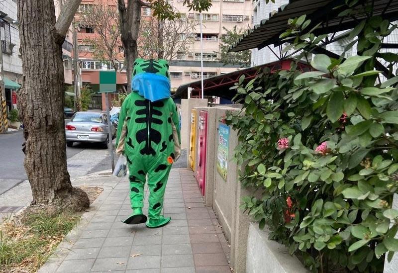 一名身著青蛙裝的男子徘徊在高雄市鳳山區一所國小校園旁，與路人了互動發糖果，引發熱議。（讀者提供）