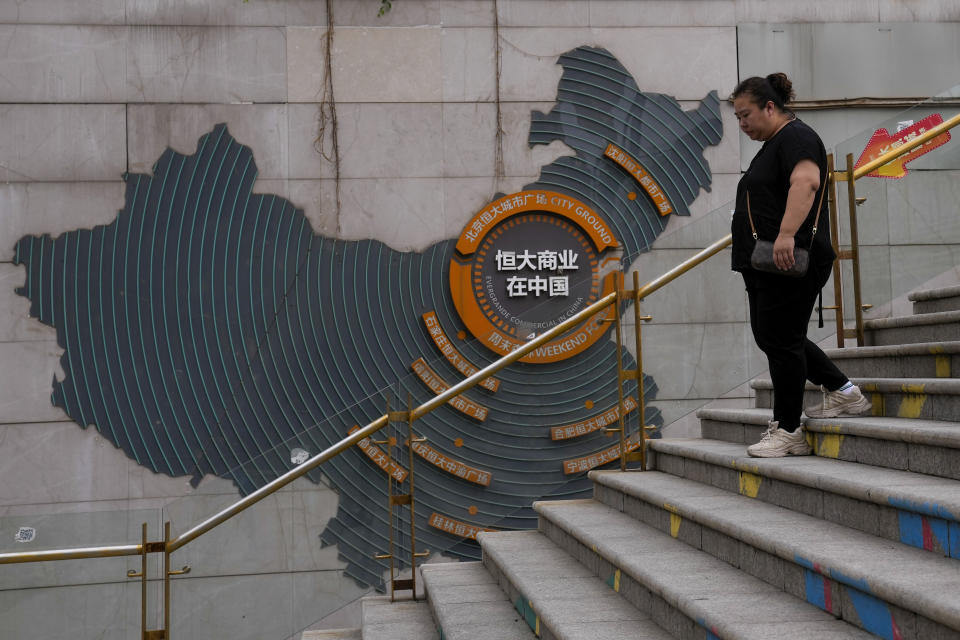 A woman walks by a map showing Evergrande development projects in China, as she heads to an Evergrande city plaza in Beijing on Sept. 18, 2023. A Hong Kong court on Monday, Oct. 30 adjourned a winding up hearing for property developer China Evergrande Group's until Dec. 4. (AP Photo/Andy Wong)