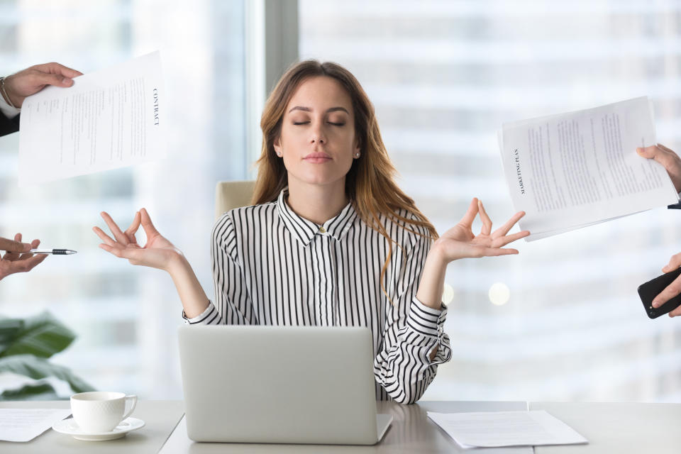 Female executive meditating at work for mental balance.