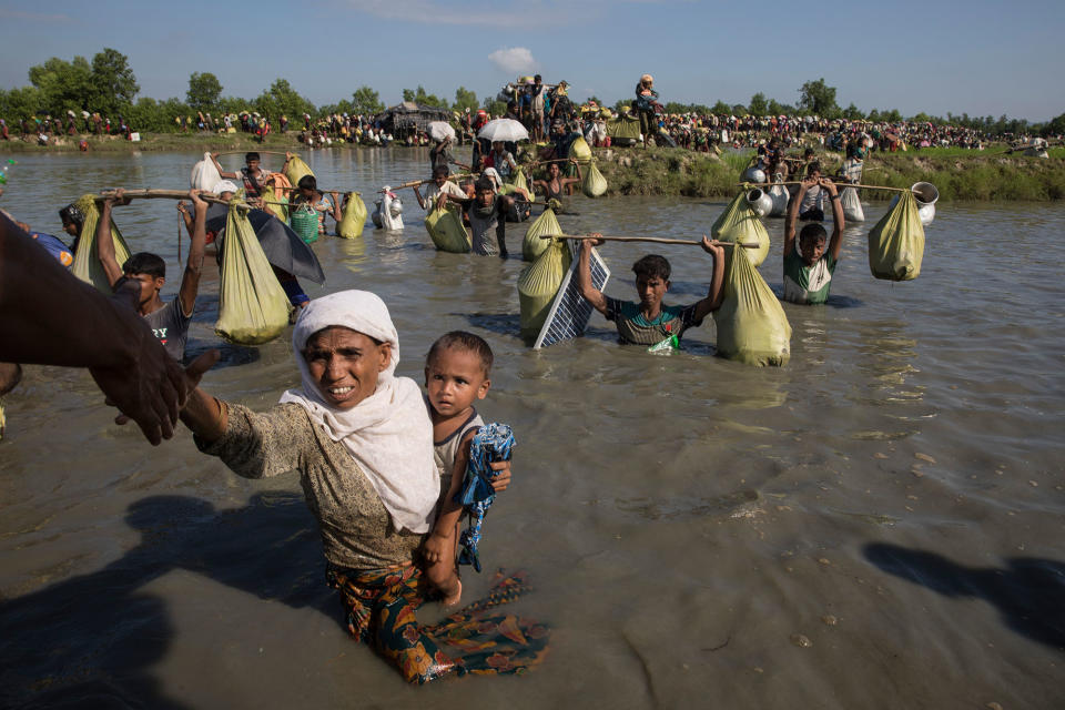 <p>Thousands of Rohingya refugees fleeing from Myanmar cross a small stream in the hot sun on a muddy rice field on October 16, 2017 near Palang Khali, Cox’s Bazar, Bangladesh, on October 16, 2017. (Photograph by Paula Bronstein/Getty Images) </p>