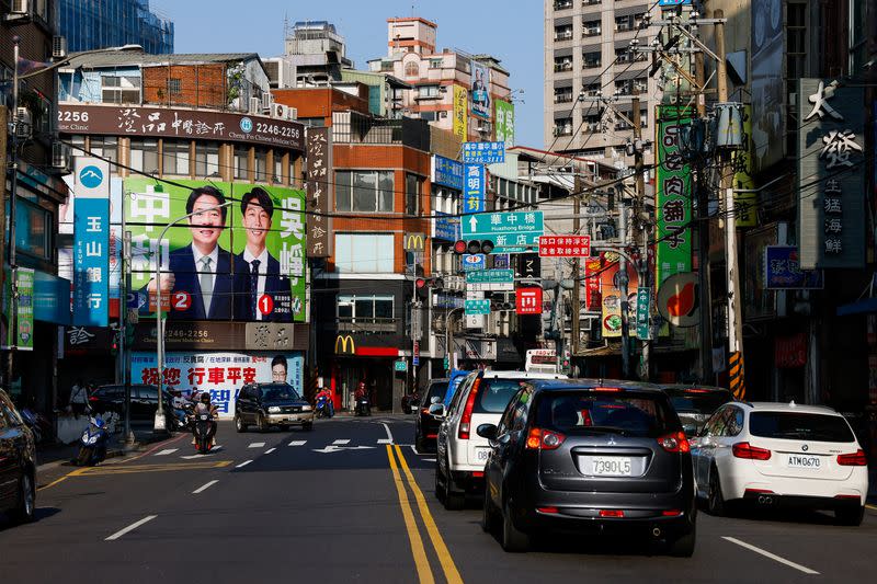 People ride pass a campaign ad