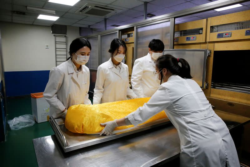 Park Bo-ram, a funeral director, moves the body of a deceased at a funeral home in a medical center in Seoul