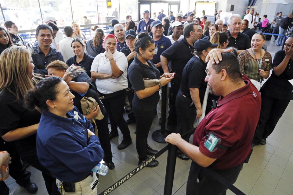 FILE - This Nov. 11, 2013 file photo shows airport employees preparing to clear security as they wait to reopen after a shooting at Terminal 3 caused a shutdown of Los Angeles International Airport. Thousands of Los Angeles International Airport workers had no idea what to do when a gunman opened fire last year or how to help because they were inadequately trained to deal with an emergency, according to a union report obtained Friday March 14, 2014. AP Photo/Reed Saxon, file)